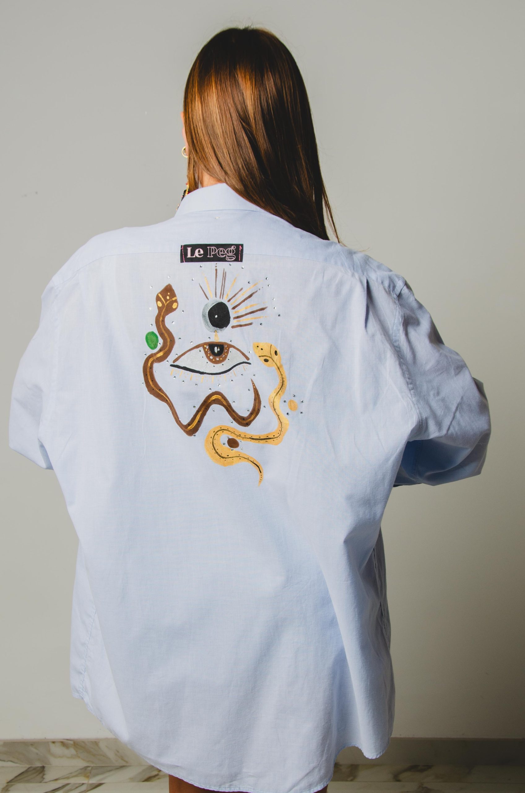 142 Camicia vintage azzurra taglio maschile YSL con dipinto sulla schiena TG L/XL - occhio e serpenti con strass