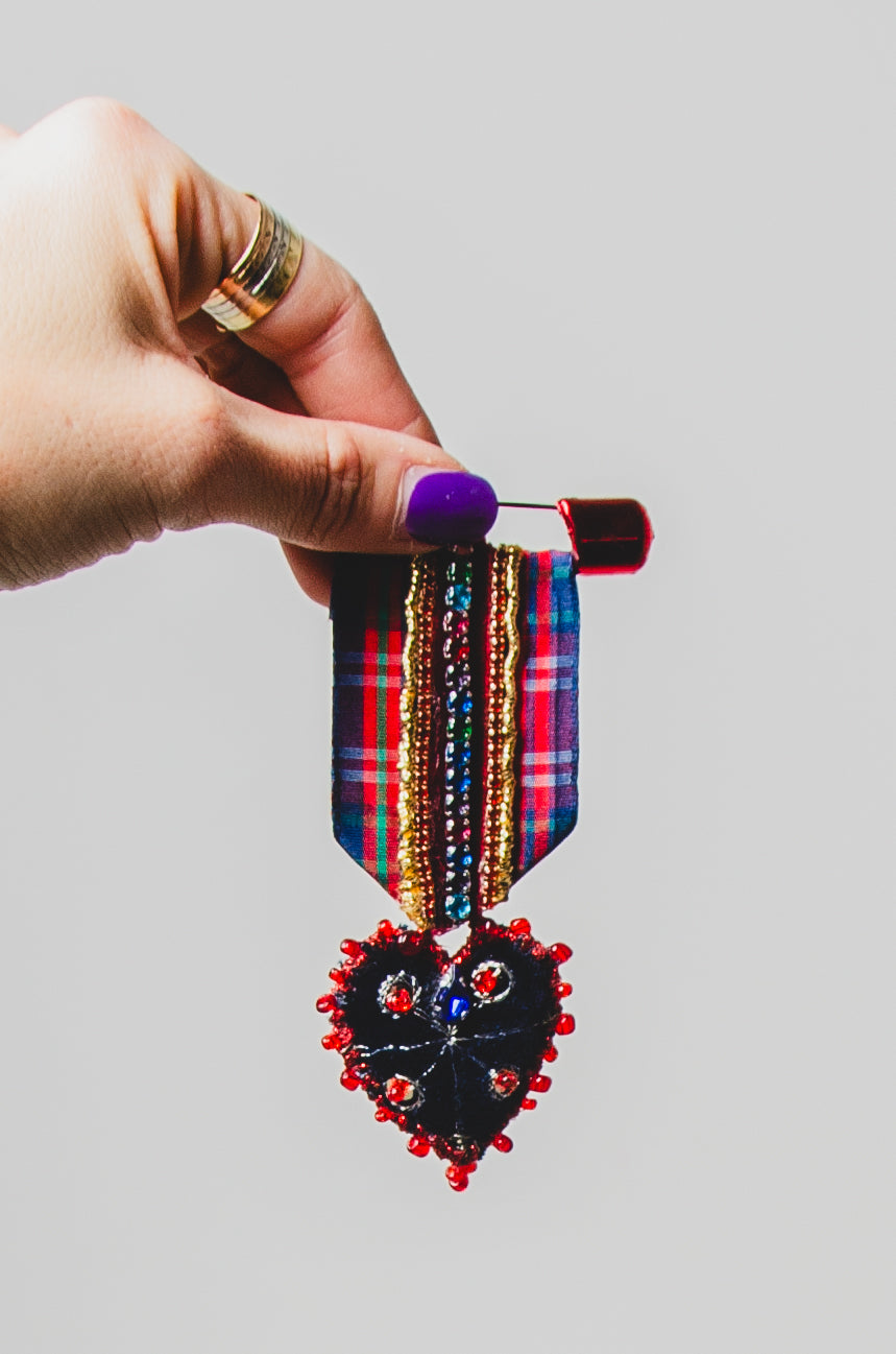 Spilla a forma di medaglia in tartan rossa e blu con cuore ricamato a mano