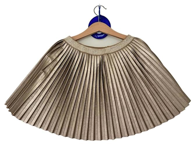 Autre Marque Ragazza con gonna a pieghe dorate D'oro